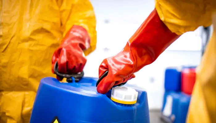 ¿Cómo reducir riesgos de contaminación en procesos industriales con hipoclorito de sodio? Personas cargando con precaución hipoclorito de sodio